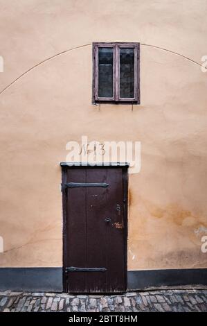 Nummer 13 über der Tür mit einem alten Fenster an der Fassade Stockfoto