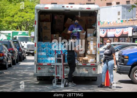 Arbeiter und Freiwillige entladen am 27. Mai 20 gespendete Lebensmittel in den Queensbridge Houses, einem öffentlichen Wohnkomplex der New York City Housing Authority (NYCHA) Stockfoto