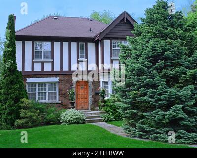 tudor Stil Haus mit großen Kiefern im Vorgarten Stockfoto