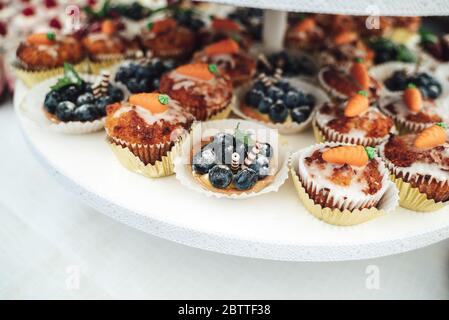 Köstliche Mini-Kuchen in Büfetts. Mit Obst dekorierte Cupcakes. Verschiedene Desserts auf Party. Feier, Party, Geburtstag oder Hochzeit Konzept. Stockfoto