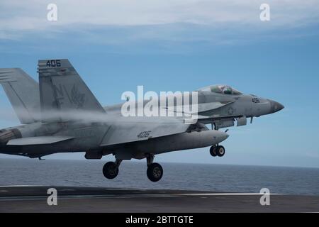 Ein US Navy F/A-18E Super Hornet Jagdflugzeug, das den Black Knights of VFA 195 zugewiesen wurde, übt eine Berührung und gehen vom Flugdeck der Nimitz-Klasse Flugzeugträger USS Ronald Reagan 26. Mai 2020 in der philippinischen See. Stockfoto