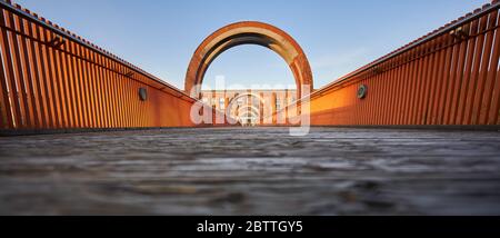 Orange Brücke zur alten Spinnerei, symmetrisch, zur goldenen Stunde.Plochingen, Deutschland Stockfoto