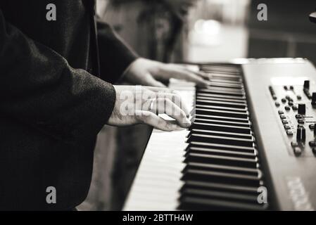 Schwarz-Weiß-Foto von Menschenhand auf elektronischen Tastaturen. Geringe Schärfentiefe. Musik, Unterhaltung, Hochzeit, Feier Konzept. Stockfoto