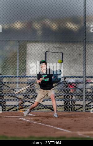 Spielen in einem gemischten Slo Pitch Softball-Spiel, mit Frauen am Fledermaus. Stockfoto