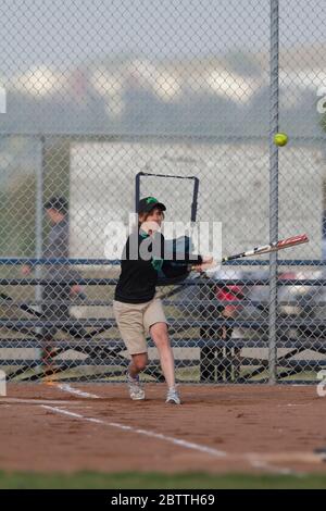 Spielen in einem gemischten Slo Pitch Softball-Spiel, mit Frauen am Fledermaus. Stockfoto