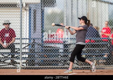 Spielen in einem gemischten Slo Pitch Softball-Spiel, mit Frauen am Fledermaus. Stockfoto