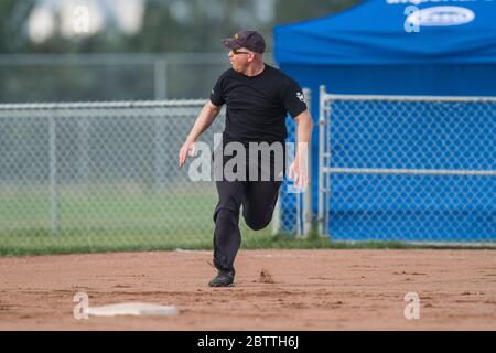 Spielen in einem gemischten Slo Pitch Softball-Spiel, männlich läuft auf die zweite Basis. Stockfoto