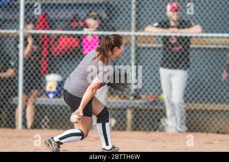 Spielen in einem gemischten Slo Pitch Softball-Spiel, weibliche Pitching. Stockfoto