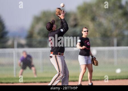 Spielen in einem gemischten Slo-Pitch Softball-Spiel, männlich fangen Fliege Ball, Stockfoto