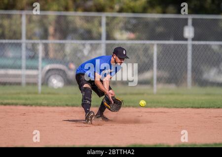 Spielen in einem gemischten Slo Pitch Softball-Spiel, männlich läuft auf die zweite Basis. Stockfoto