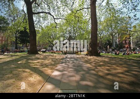 Soho Square in London an einem sonnigen Tag mit Menschen entspannen und Sonnenbaden. Stockfoto