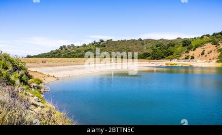 Stevens Creek Reservoir an einem sonnigen Tag, mit Menschen zu Fuß und entspannen auf dem Damm und Küste; südlich San Francisco Bay Area, Kalifornien Stockfoto
