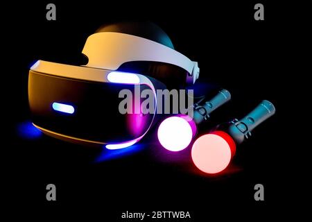 PlayStation Virtual Reality System, PSVR mit Move-Motion-Controllern, die vor schwarzem Hintergrund leuchten. Stockfoto