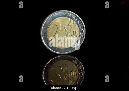 Nahaufnahme einer 2-Euro-Münze vor schwarzem Hintergrund mit Spiegelung. Stockfoto