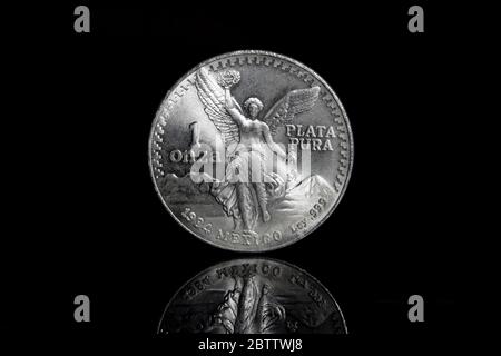 Eine Unze mexikanische Libertad Silber Bullion Münze vor einem schwarzen Hintergrund mit Reflexion. Stockfoto
