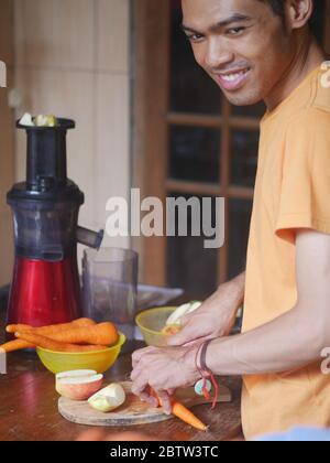 14. April 2019 - Kediri, Indonesien: Ein junger indonesischer Mann, der Gemüsesaft zu Hause zubereitete Stockfoto