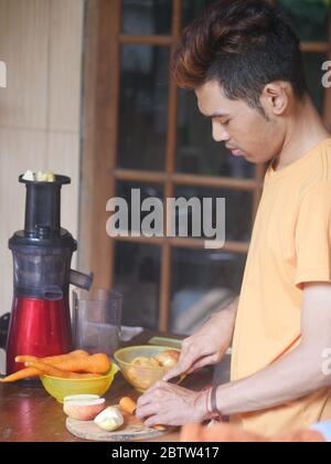 14. April 2019 - Kediri, Indonesien: Ein junger indonesischer Mann, der Gemüsesaft zu Hause zubereitete Stockfoto