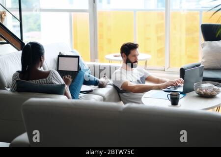 Paar Arbeiten Und Spielen Mit Laptop-Computer Zu Hause Stockfoto