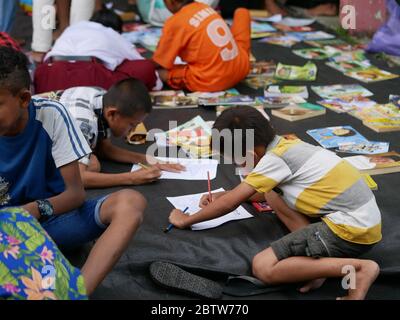 27. Jan 2020- Tarakan/Indonesien: Flüchtlingskinder mit Feuer färben ein Buch, das von Freiwilligen am Nachmittag in Tarakan, Indonesien, verteilt wurde Stockfoto