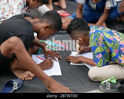 27. Jan 2020- Tarakan/Indonesien: Flüchtlingskinder mit Feuer färben ein Buch, das von Freiwilligen am Nachmittag in Tarakan, Indonesien, verteilt wurde Stockfoto