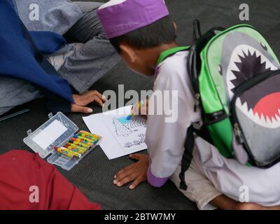 27. Jan 2020- Tarakan/Indonesien: Flüchtlingskinder mit Feuer färben ein Buch, das von Freiwilligen am Nachmittag in Tarakan, Indonesien, verteilt wurde Stockfoto