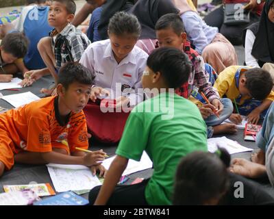 27. Jan 2020- Tarakan/Indonesien: Flüchtlingskinder mit Feuer färben ein Buch, das von Freiwilligen am Nachmittag in Tarakan, Indonesien, verteilt wurde Stockfoto