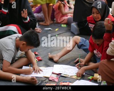 27. Jan 2020- Tarakan/Indonesien: Flüchtlingskinder mit Feuer färben ein Buch, das von Freiwilligen am Nachmittag in Tarakan, Indonesien, verteilt wurde Stockfoto