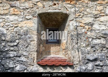 Kleines rechteckiges Fenster in einer dicken Wandnische mit roten Backsteinkanten von Schloss Lichtenstein, in Deutschland auf der schönen Schwäbischen Alb Stockfoto