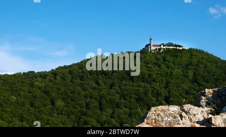 Blick auf Schloss Teck vom Hügel ragt ein kleiner Fels ins Bild.Blauer Himmel im Sommer.Owen, Deutschland. Stockfoto