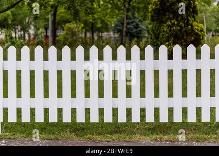 Weiße Holzzäune rund um den Garten Stockfoto