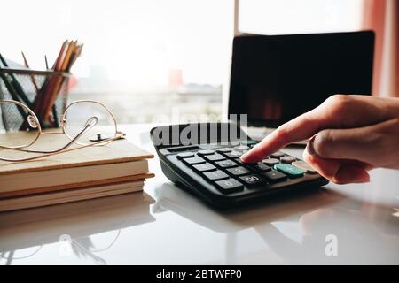 Close up Geschäftsfrau mit Rechner und Laptop für tun Mathematik Finanzen auf Holzschreibtisch im Büro Stockfoto