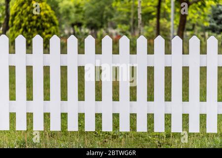 Weiße Holzzäune rund um den Garten Stockfoto