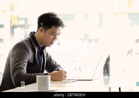 Junge asiatische gut aussehend männlichen Kunden-Support-Telefon Betreiber Stockfoto