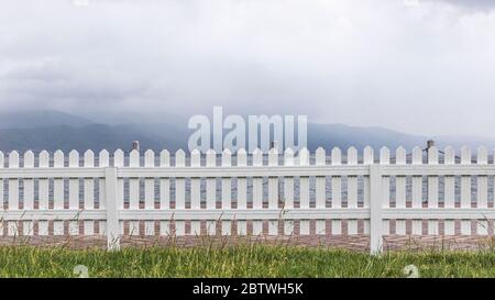 Weiße Holzzäune rund um den Garten Stockfoto