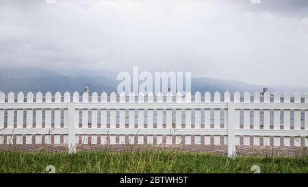 Weiße Holzzäune rund um den Garten Stockfoto