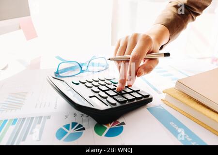 Nahaufnahme von Buchhalterin oder Bankerin, die Berechnungen anstellt. Einsparungen, Stockfoto