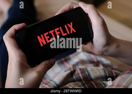 CHIANG MAI, THAILAND, 29. MÄRZ 2020: Frau Hand hält Smartphone mit Netflix-Logo auf Apple iPhone XS zu Hause. Stockfoto