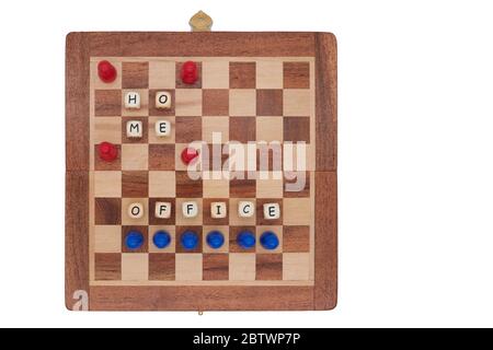 Rote Spielsteine auf einem kleinen Schachbrett machen Heimbüro und bleiben in der Ferne Stockfoto