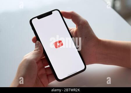 CHIANG MAI, THAILAND - 17. NOVEMBER 2019: Frau mit iPhone XS und Youtube-Apps auf dem Bildschirm. Stockfoto