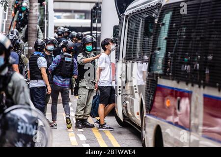 Hongkong, China. Mai 2020. Während der Demonstration transportierte ein Polizist einen verhafteten Protestierenden.als Demonstranten gegen ein Gesetz protestierten, das die Beleidigung der chinesischen Nationalhymne kriminalisieren würde, marschierten sie auf den Straßen und skandierten Lieder und Parolen. Später tauchte die Polizei in Bereitschaftspolizei auf und feuerte Pfefferspray ab, um mehrere Demonstranten zu verhaften. Quelle: SOPA Images Limited/Alamy Live News Stockfoto