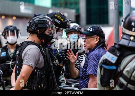 Hongkong, China. Mai 2020. Ein Mann starrte während der Demonstration einen Polizisten an.als Demonstranten gegen ein Gesetz protestierten, das die Beleidigung der chinesischen Nationalhymne kriminalisieren würde, marschierten sie auf die Straße und skandierten Lieder und Parolen. Später tauchte die Polizei in Bereitschaftspolizei auf und feuerte Pfefferspray ab, um mehrere Demonstranten zu verhaften. Quelle: SOPA Images Limited/Alamy Live News Stockfoto