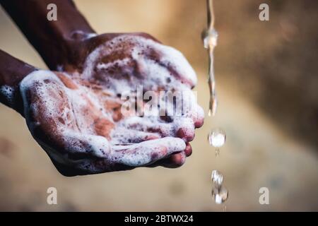 Händewaschen. Mann, der sich die Hände im Garten zu Hause wäscht. Corona Virus Pandemie Prävention waschen Hände mit Seife warmes Wasser und reiben Nägel und fing Stockfoto