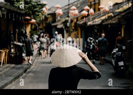 Tourist Frau trägt vietnam Hut oder Non La und Sightseeing in Heritage Village in Hoi an Stadt in Vietnam Stockfoto