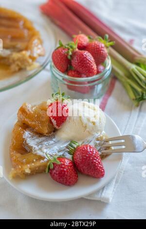 Rhabarber umgedrehten Kuchen mit Erdbeeren und Eis Stockfoto