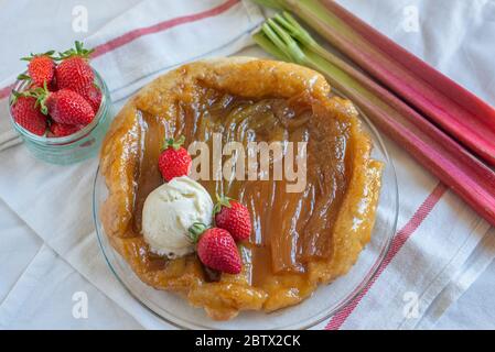 Rhabarber umgedrehten Kuchen mit Erdbeeren und Eis Stockfoto