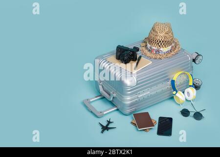 Reisegepäck mit Reisepass, Kamera, Hut, Brieftasche, Flugzeug Spielzeug und Smartphone isoliert auf blauem Hintergrund mit Kopierraum, Travel Concept Hintergrund Stockfoto