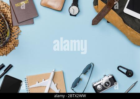 Draufsicht Mockup von Reisenden Zubehör mit Reisepass, Bücher von Reiseplan, Brieftasche, Kamera, Hut, Rucksack und Flugzeug Spielzeug isoliert bunten blauen b Stockfoto