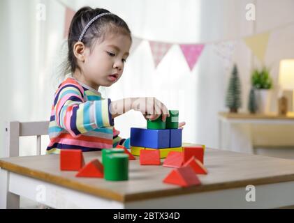 Kinder Kreativität, Kind kleine asiatische Mädchen spielen bunte Bausteine auf dem Schreibtisch im Klassenraum zu Hause, Bildungskonzept für die Schule Stockfoto