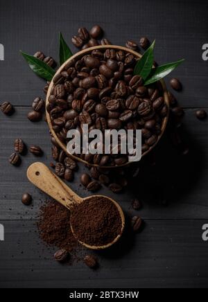 Kaffeebohnen und das gemahlene Kaffeepulver auf dem Holztisch Stockfoto