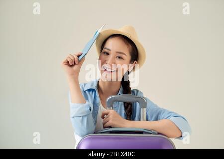 Überfreudiger Tourist, der abseits schaut und Tickets hält, grauer Hintergrund, freier Platz. Stockfoto